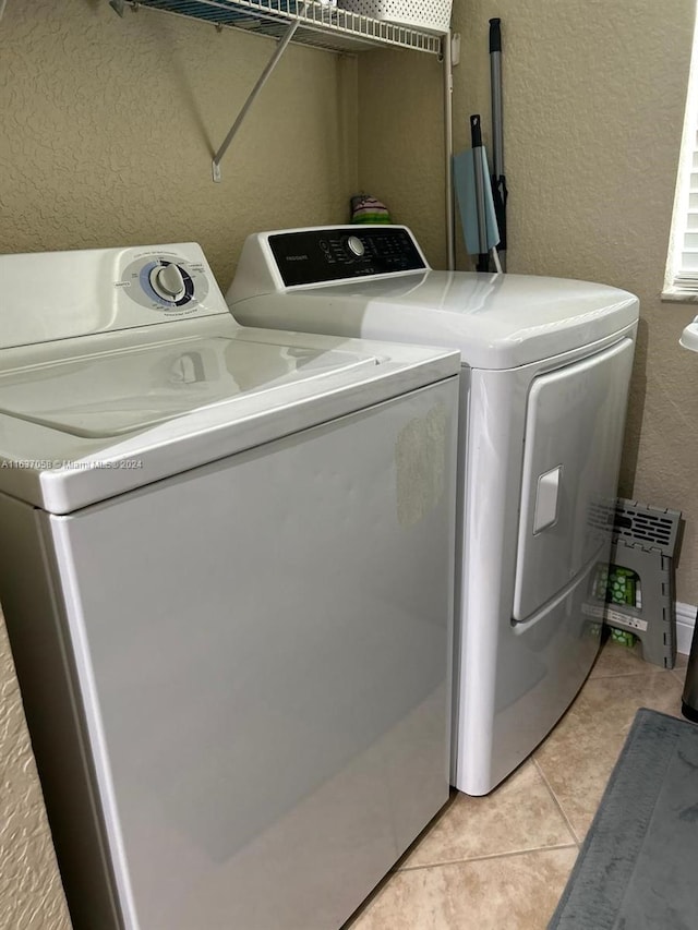 washroom with light tile patterned flooring and washer and dryer