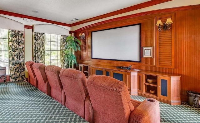 carpeted cinema room featuring wood walls and ornamental molding