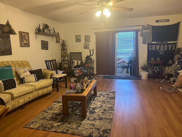 living room featuring a textured ceiling, hardwood / wood-style flooring, and ceiling fan