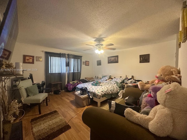 bedroom featuring a textured ceiling, light wood-type flooring, and ceiling fan