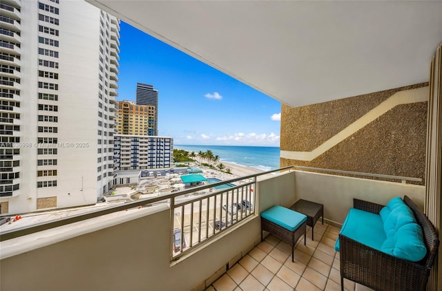 balcony with a view of the beach, a water view, and a view of city