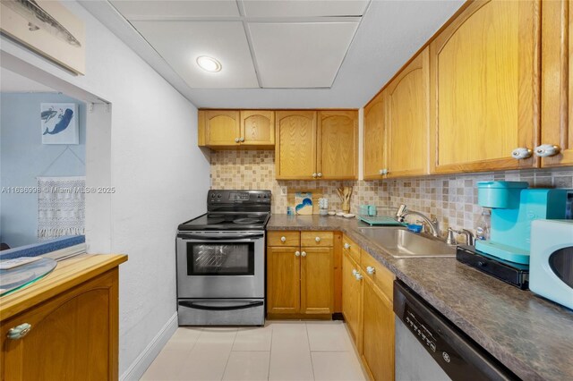 kitchen with light tile patterned floors, stainless steel appliances, tasteful backsplash, and sink