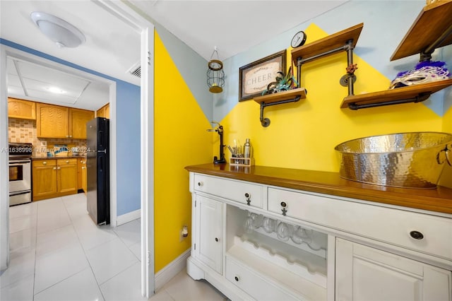 interior space featuring range, tasteful backsplash, and black fridge