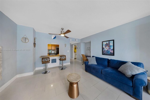 living room featuring ceiling fan and light tile patterned floors