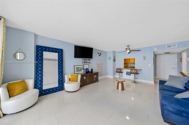 living room with tile patterned flooring and ceiling fan