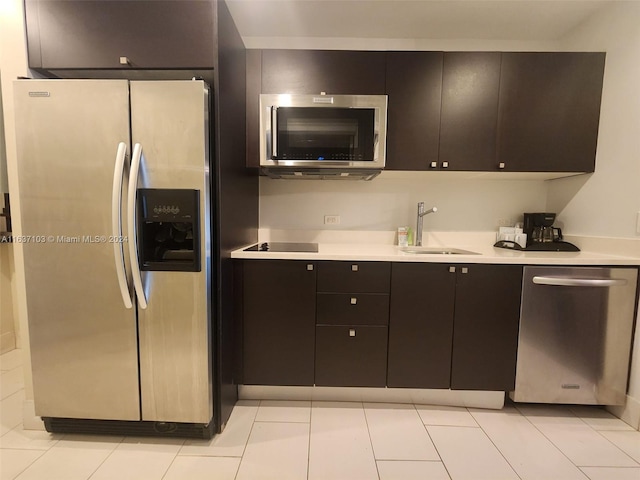 kitchen featuring dark brown cabinets, sink, appliances with stainless steel finishes, and light tile patterned floors