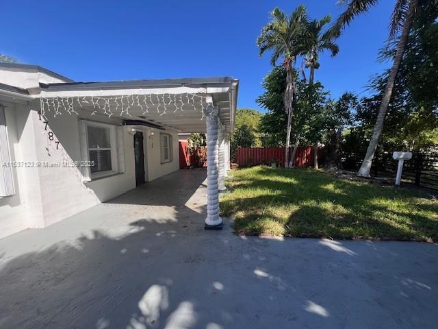 view of yard featuring a carport and fence