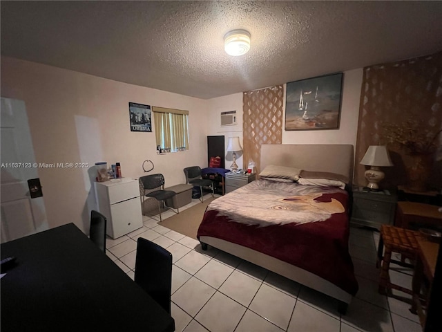 bedroom featuring a textured ceiling, light tile patterned floors, and a wall mounted air conditioner