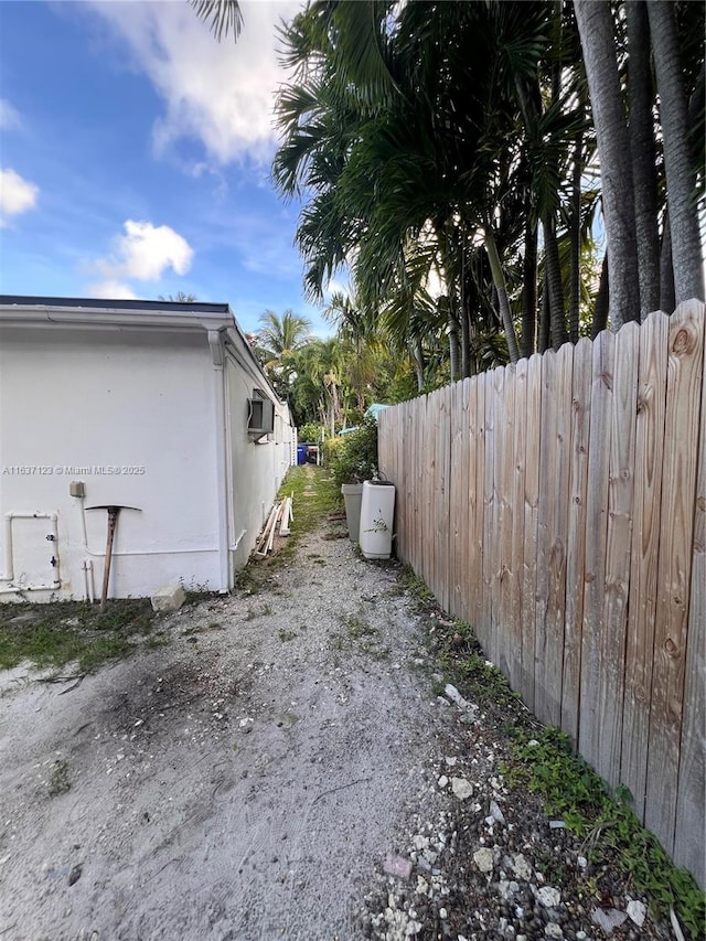 view of side of property with fence and stucco siding