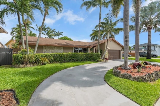 ranch-style home featuring a garage and a front yard