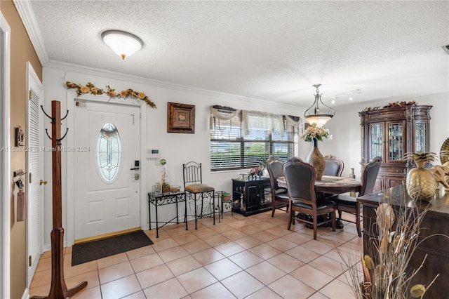 tiled entrance foyer featuring crown molding and a textured ceiling