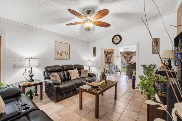 tiled living room with ceiling fan, a textured ceiling, and crown molding