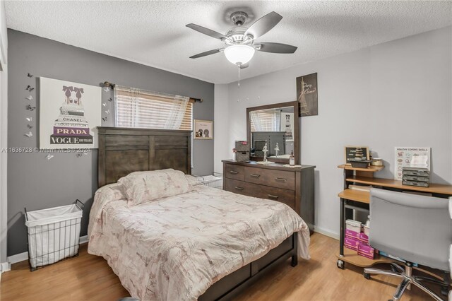 bedroom with ceiling fan, light hardwood / wood-style flooring, and multiple windows