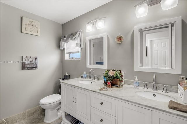 bathroom featuring tile patterned flooring, toilet, and dual vanity