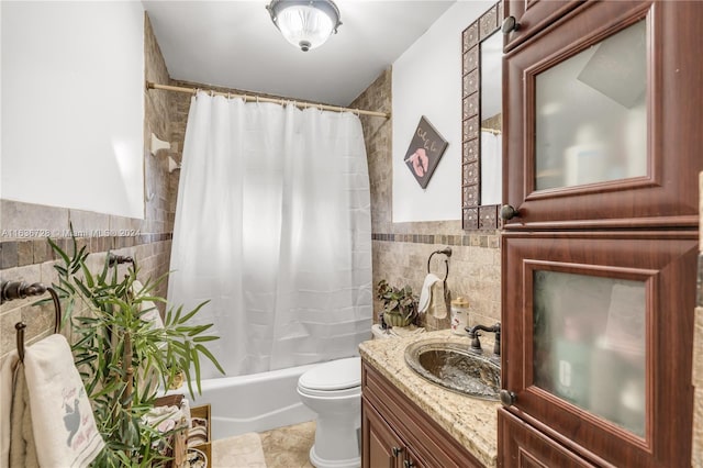 full bathroom with tile patterned floors, shower / tub combo, vanity, tile walls, and toilet