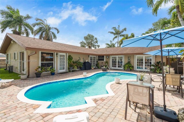 view of swimming pool with a patio area and french doors