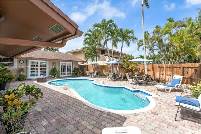 view of swimming pool featuring french doors and a patio area