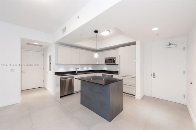 kitchen featuring stainless steel appliances, white cabinets, sink, and pendant lighting