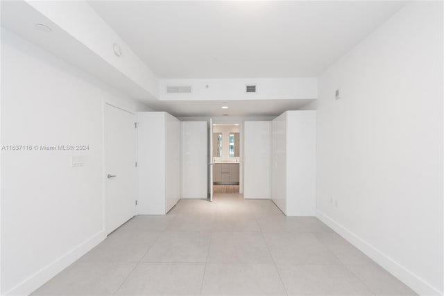 hall with light tile patterned floors