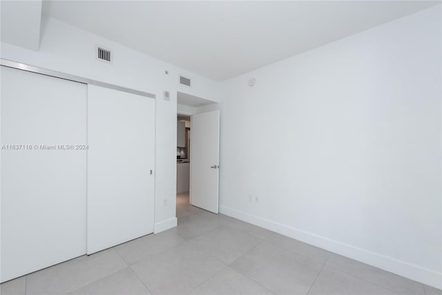 unfurnished bedroom with a closet and light tile patterned floors