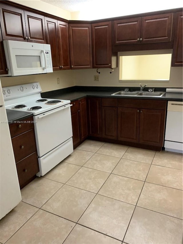 kitchen featuring sink, light tile patterned floors, and white appliances