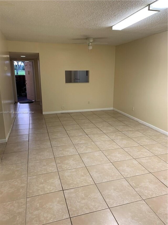 tiled spare room with a textured ceiling