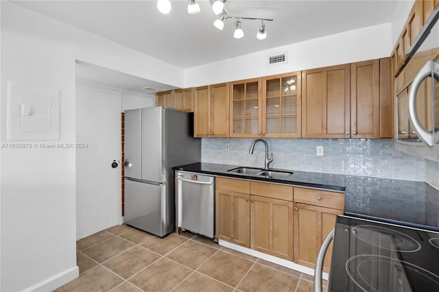 kitchen featuring light tile patterned floors, sink, stainless steel appliances, and rail lighting