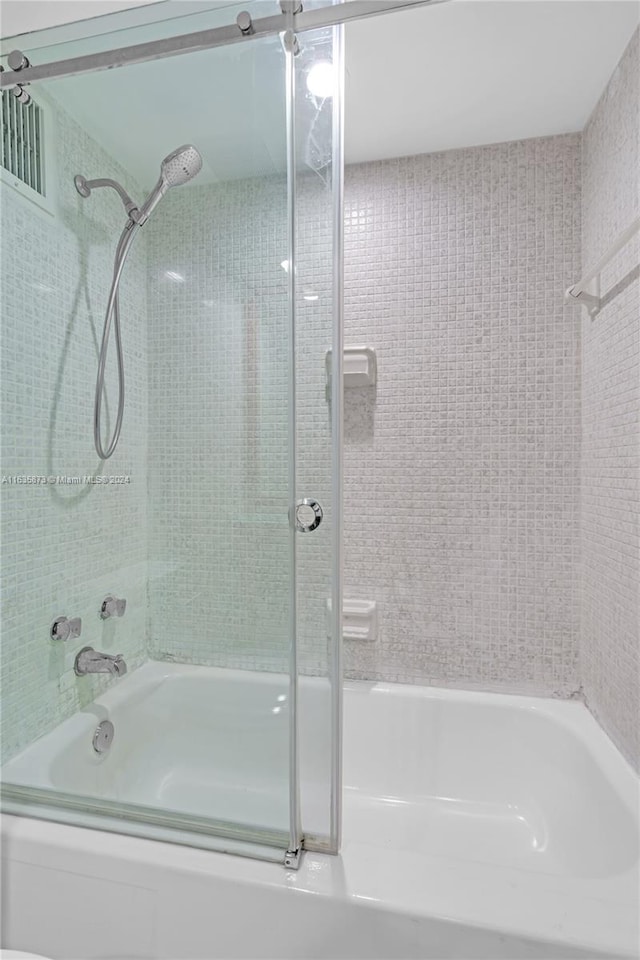 bathroom featuring combined bath / shower with glass door