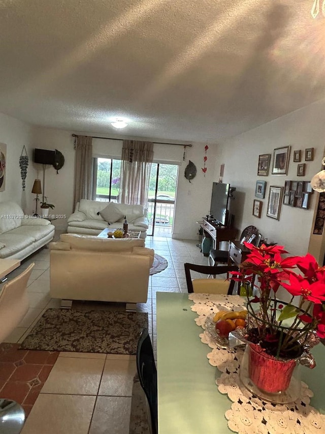 living room with a textured ceiling and light tile patterned floors