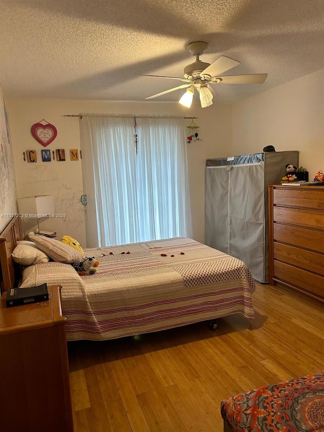 bedroom featuring ceiling fan, a textured ceiling, and hardwood / wood-style flooring