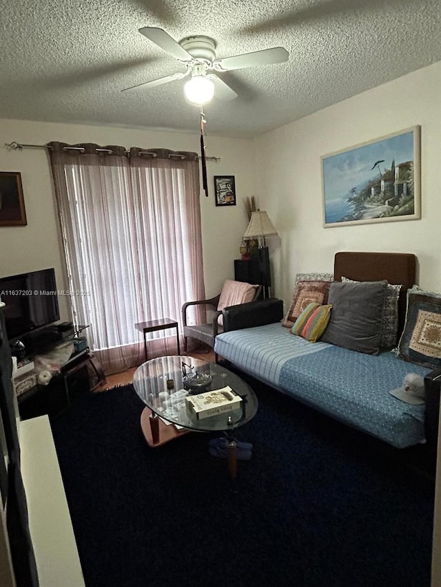 living room featuring a textured ceiling and ceiling fan