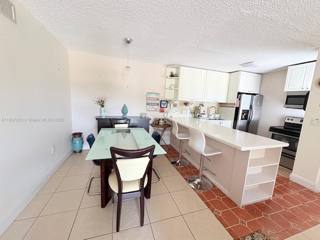 kitchen featuring light countertops, open shelves, stainless steel appliances, and a peninsula