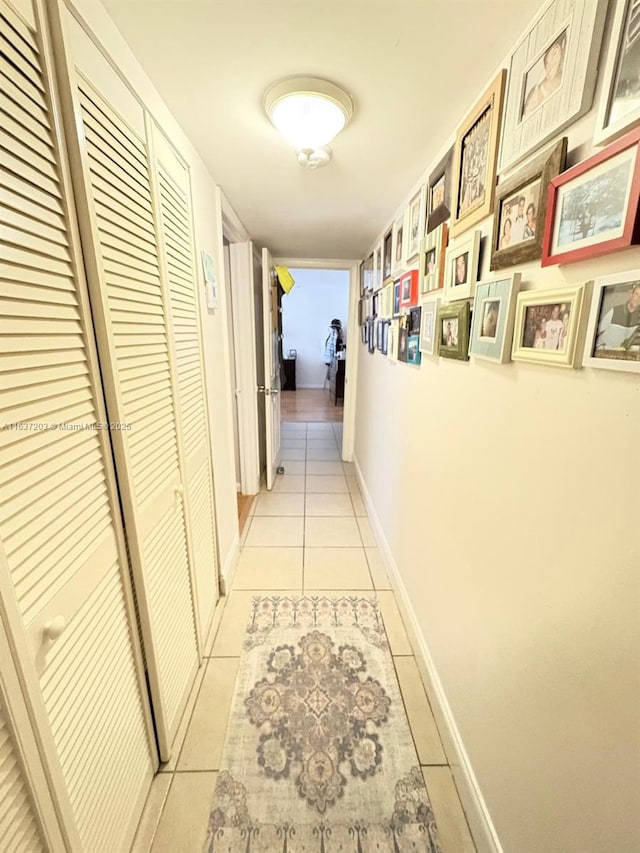 hallway featuring light tile patterned floors and baseboards
