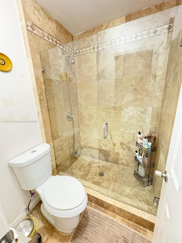 bathroom with a shower stall and toilet