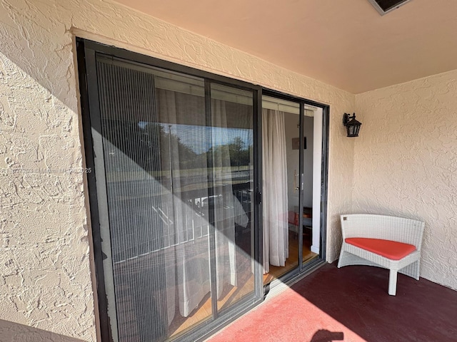 view of exterior entry featuring visible vents and stucco siding