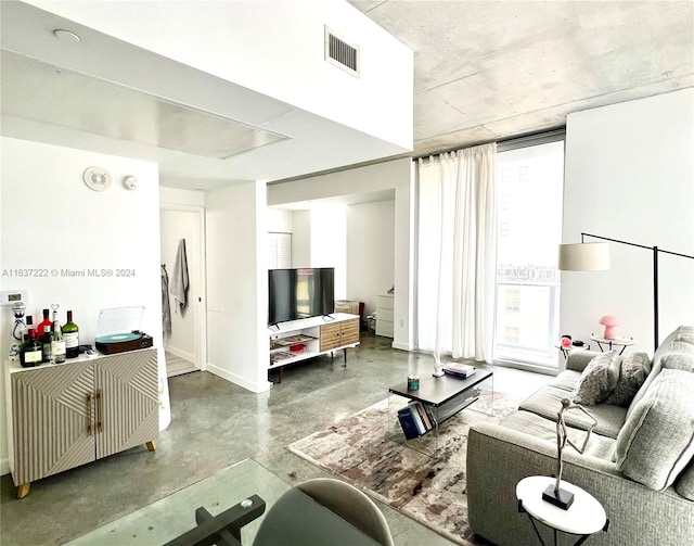 living room featuring a wealth of natural light and concrete floors