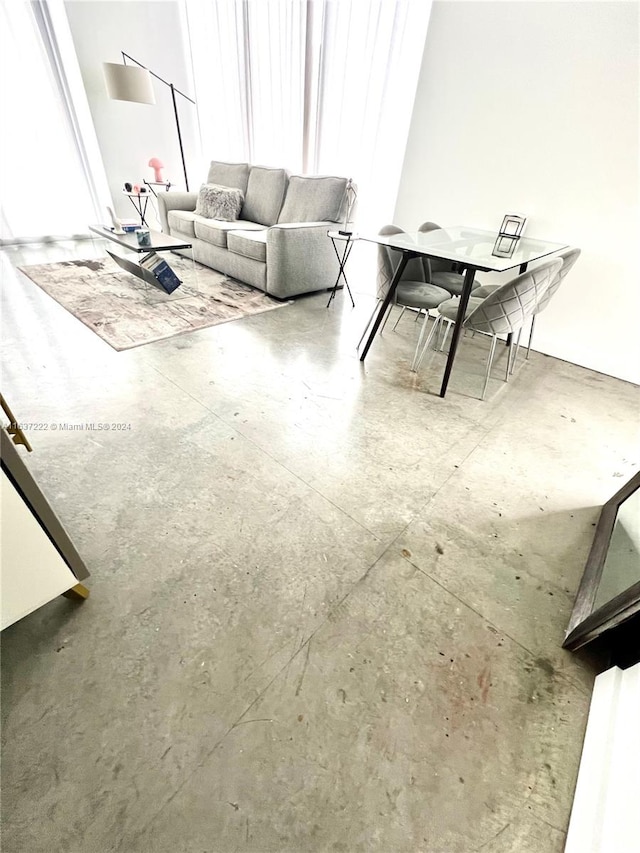 unfurnished living room with a wealth of natural light and concrete flooring