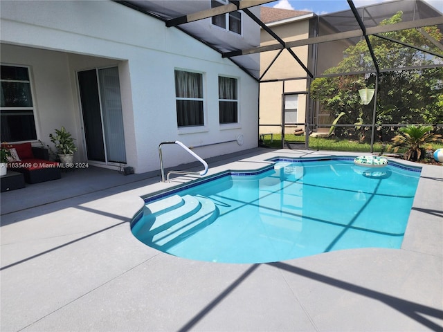 view of swimming pool featuring a patio area and glass enclosure