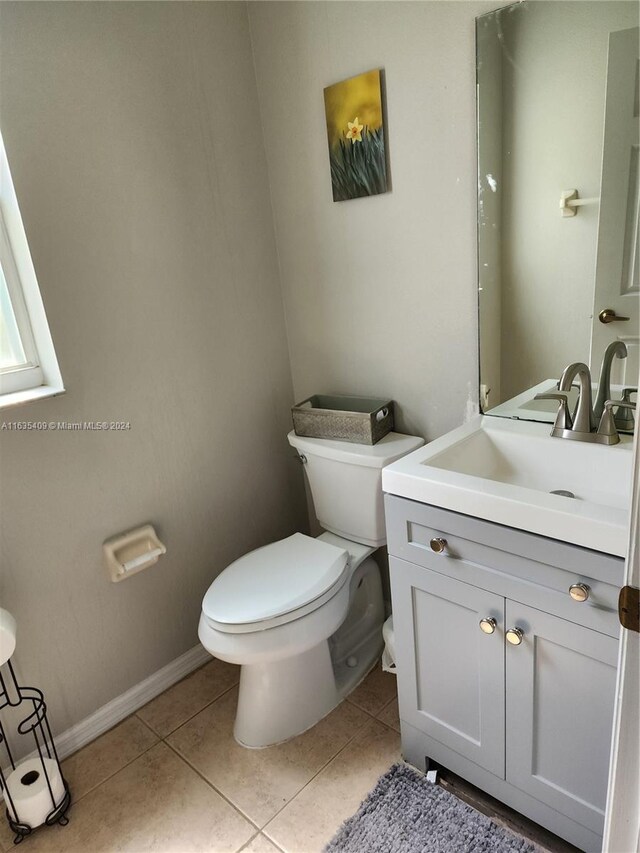 bathroom with vanity, tile patterned flooring, and toilet