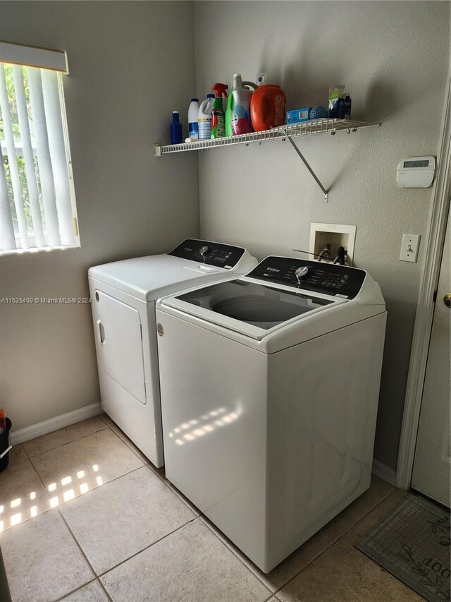 laundry room with independent washer and dryer and light tile patterned floors