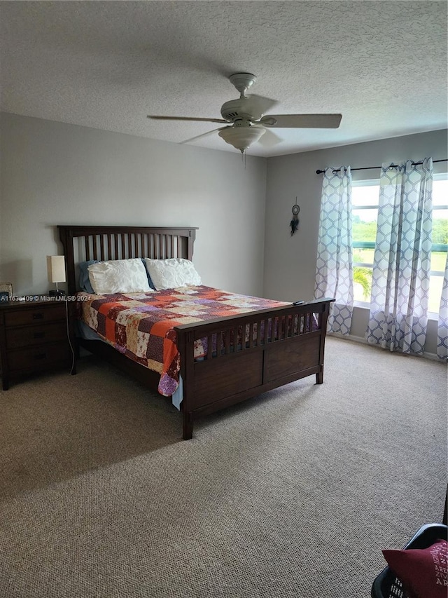 carpeted bedroom featuring a textured ceiling and ceiling fan