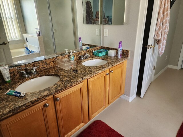 bathroom with a tub to relax in and dual bowl vanity