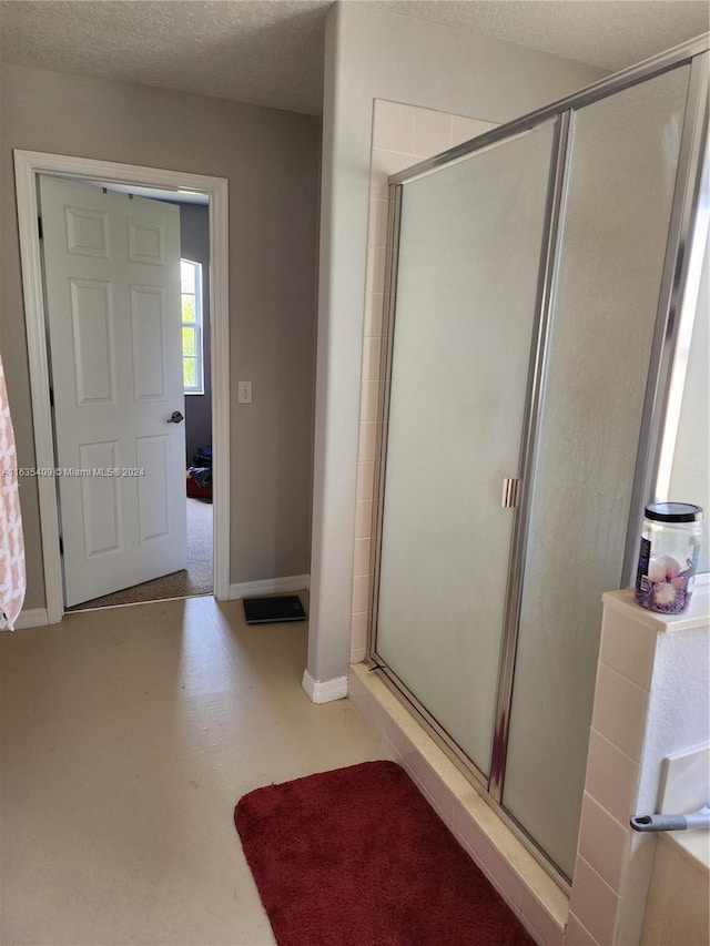 bathroom with an enclosed shower and a textured ceiling