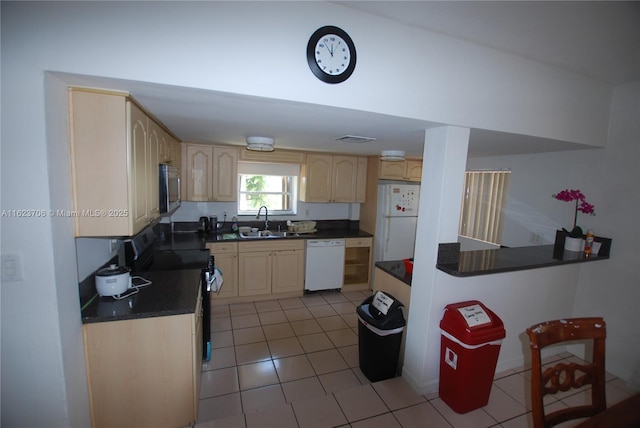 1801 NE 176th St, North Miami Beach, FL 33162 - kitchen with light brown cabinetry, dark countertops, a sink, white appliances, and light tile patterned floors
