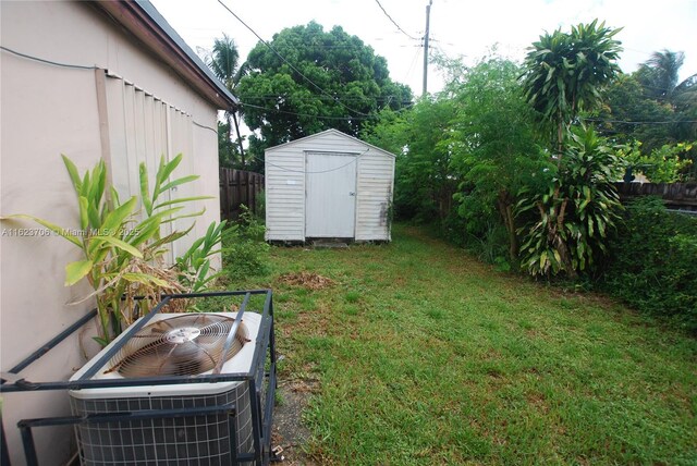 1801 NE 176th St, North Miami Beach, FL 33162 - view of yard with a storage shed, fence, central air condition unit, and an outbuilding