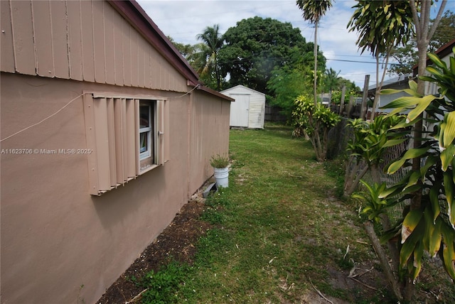 1801 NE 176th St, North Miami Beach, FL 33162 - view of property exterior with a storage unit, an outdoor structure, a lawn, and fence