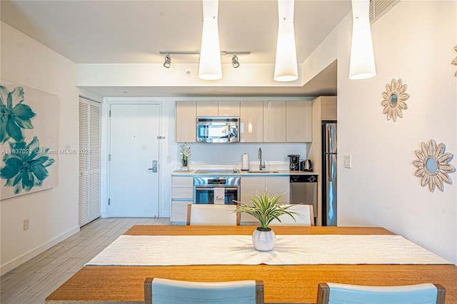 kitchen with rail lighting, appliances with stainless steel finishes, and sink