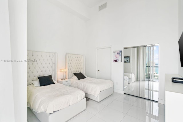 tiled bedroom featuring a towering ceiling