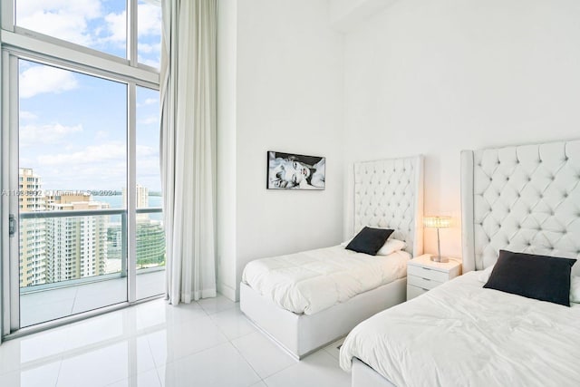 tiled bedroom with access to outside, a high ceiling, and multiple windows