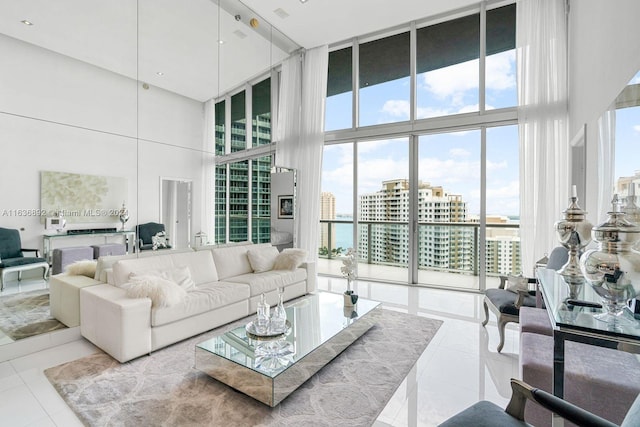 tiled living room with floor to ceiling windows and a high ceiling